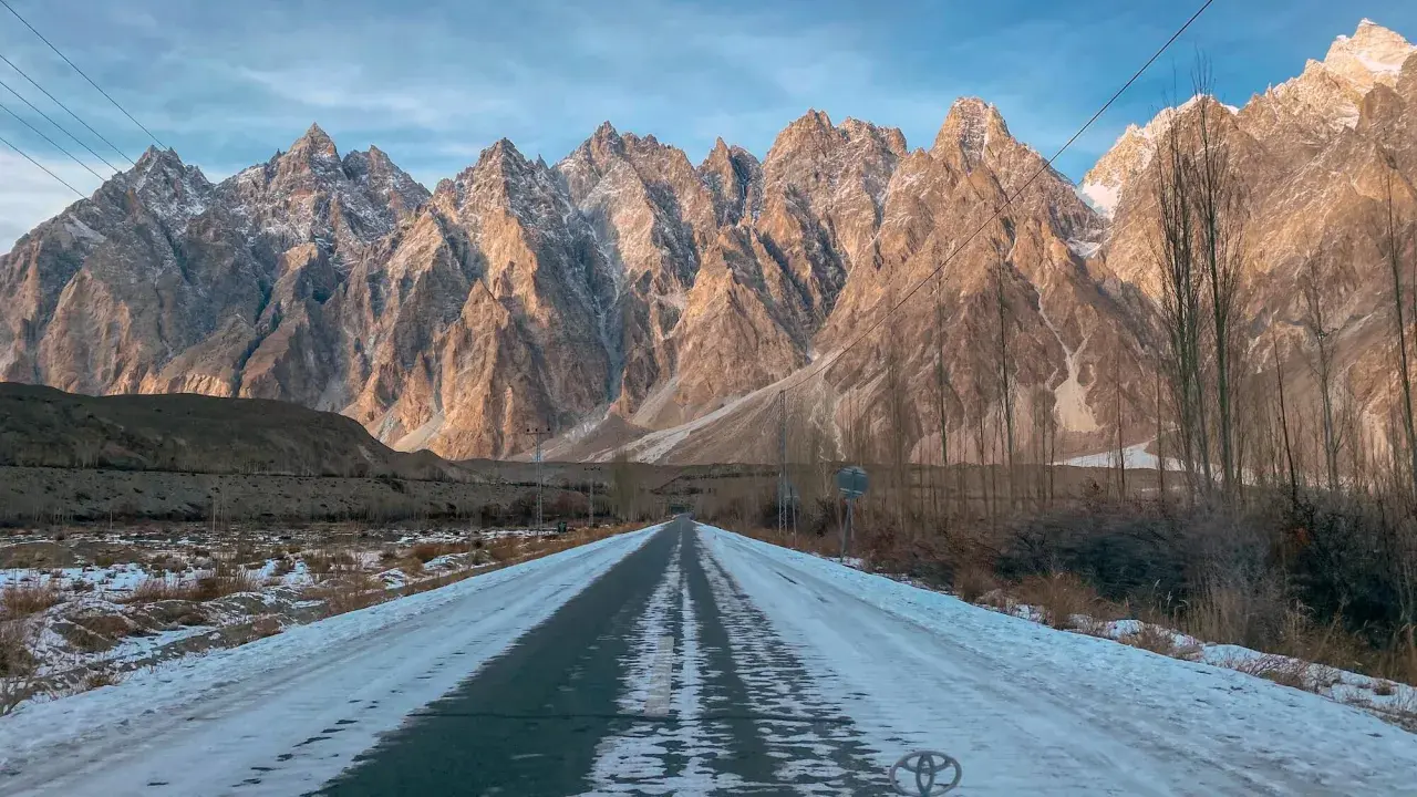 Droga przez ośnieżoną dolinę w kierunku majestatycznych gór Hunza.