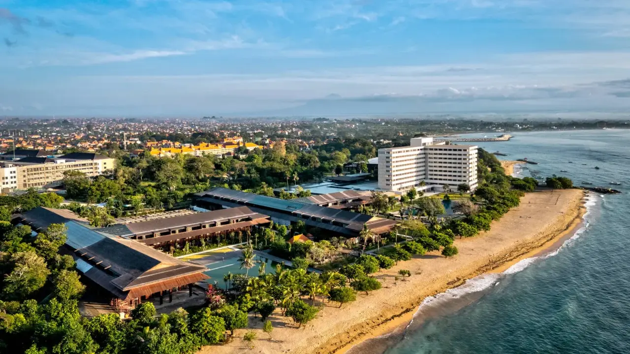Widok z lotu ptaka na wybrzeże Sanur z hotelami, basenami i plażą.