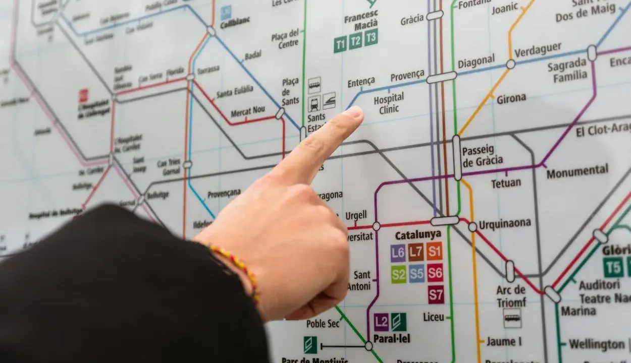 Palec na mapie metra w Barcelonie, wskazujący drogę do Hospital Clínic. Planujesz podróż z lotniska Barcelona?