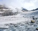 Grupa turystów wędruje po lodowcu w kierunku majestatycznego masywu Monte Rosa.