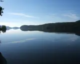Spokojne, lustrzane odbicie lasu i nieba w największym jeziorze w Europie.