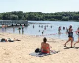 Ludzie kąpią się i opalają nad wodą, ciesząc się jednym z najładniejszych jezior w Wielkopolsce.