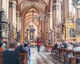 Wnętrze katedry we Fromborku, gdzie zwiedzający słuchają przewodniczki. Zamek Frombork zachwyca bogactwem zdobień.