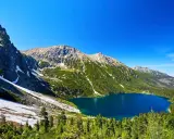 Malowniczy widok na Morskie Oko, idealne miejsce na górską trasę. Błękitne jezioro otoczone zielonymi lasami i skalistymi szczytami Tatr.