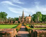 Ruiny świątyń w historycznym parku Sukhothai, wpisanym na listę 7 cudów świata UNESCO, z posągiem Buddy i wieżami.