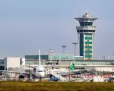 Wieża kontroli lotów i samoloty na jednym z lotnisk w Paryżu.