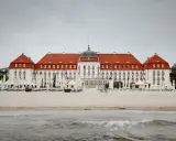 Majestatyczny Grand Hotel Sopot, z czerwoną dachem i białymi fasadami, stoi nad morzem. Jego historia jest równie imponująca jak widok.