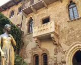 Posąg Julii stoi przed murem z balkonem, który przypomina o miasto Romea i Julii.