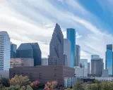 Widok na centrum Houston, największe miasto Teksasu, z drapaczami chmur i drzewami w jesiennych barwach.