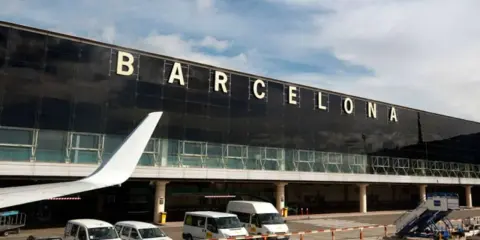 Terminal Barcelona El Prat. Samoloty, busy vans and cars waiting for passengers.