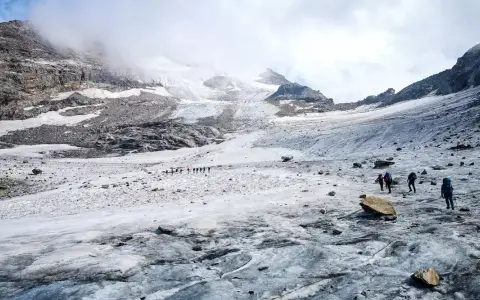 Grupa turystów wędruje po lodowcu w kierunku majestatycznego masywu Monte Rosa.