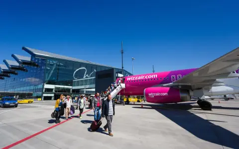 Pasażerowie wsiadają do różowego samolotu Wizz Air na jednym z portów lotniczych w Polsce.