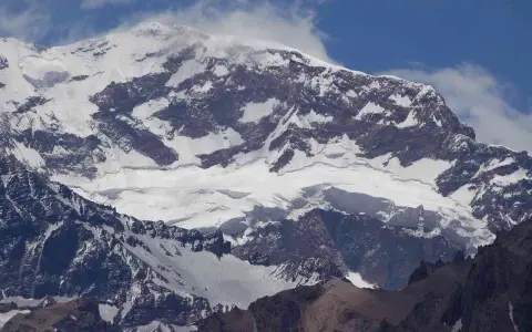 Aconcagua, najwyższy szczyt Andów, pokryty śniegiem i lodem, majestatycznie wznosi się ku błękitnemu niebu.