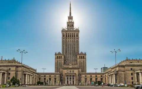 Imponujący Pałac Kultury i Nauki w Warszawie, jego monumentalna wysokość dominuje nad placem.