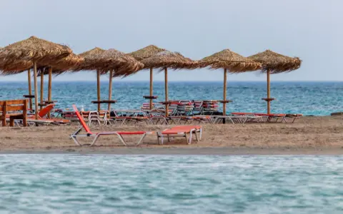 Plaża Elafonisi z rzędem słomianych parasoli i leżaków, gotowa na gości.