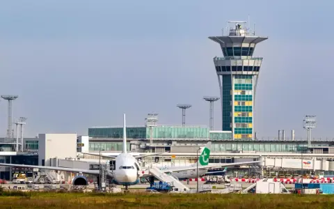 Wieża kontroli lotów i samoloty na jednym z lotnisk w Paryżu.