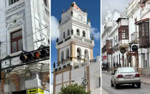 Architektura Sucre: wieża zegarowa, białe budynki z balkonami i uliczka z samochodem.