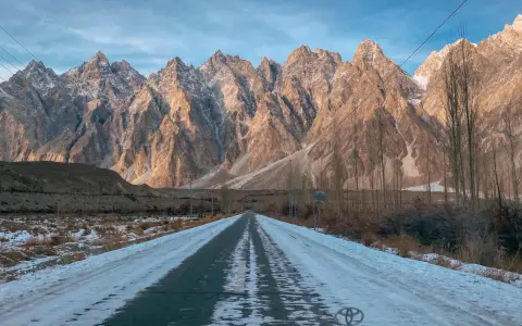 Droga przez ośnieżoną dolinę w kierunku majestatycznych gór Hunza.
