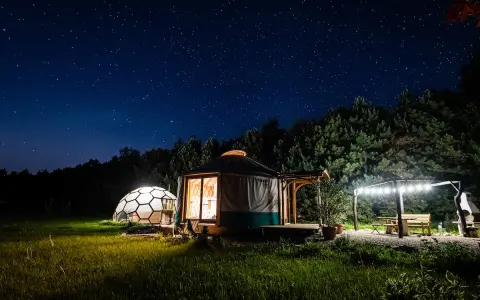 Nocne niebo nad jurta i kopułą. Idealne romantyczne miejsca w Polsce na wspólne chwile pod gwiazdami.