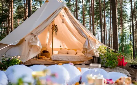 Glamping co to? Luksusowy namiot w lesie, z wygodnym łóżkiem i dekoracjami, zaprasza do odpoczynku na łonie natury.