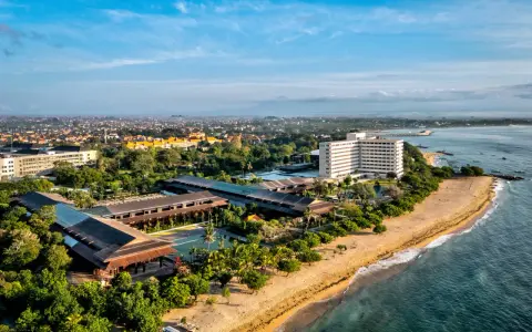 Widok z lotu ptaka na wybrzeże Sanur z hotelami, basenami i plażą.