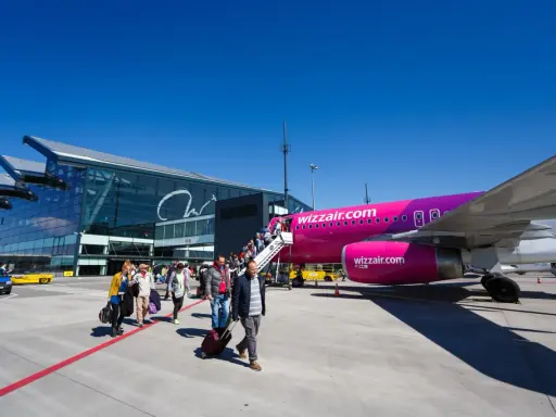 Pasażerowie wsiadają do różowego samolotu Wizz Air na jednym z portów lotniczych w Polsce.