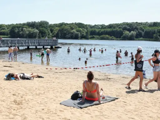Ludzie kąpią się i opalają nad wodą, ciesząc się jednym z najładniejszych jezior w Wielkopolsce.