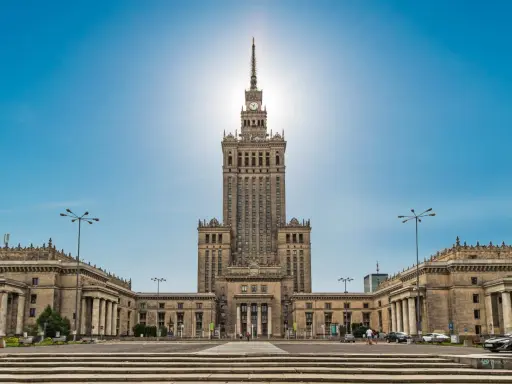Imponujący Pałac Kultury i Nauki w Warszawie, jego monumentalna wysokość dominuje nad placem.