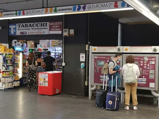 Przystanek autobusowy w Rzymie Ciampino. Ludzie kupują bilety i artykuły w sklepie.
