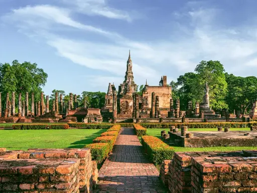 Ruiny świątyń w historycznym parku Sukhothai, wpisanym na listę 7 cudów świata UNESCO, z posągiem Buddy i wieżami.