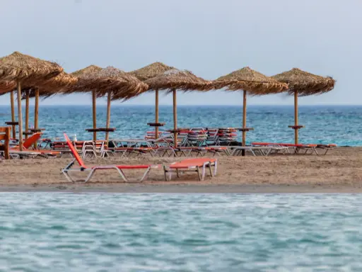 Plaża Elafonisi z rzędem słomianych parasoli i leżaków, gotowa na gości.