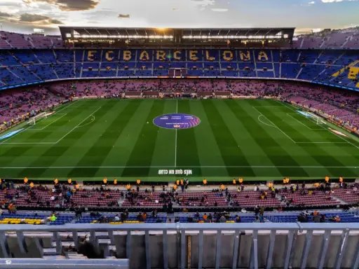Widok na Camp Nou podczas zwiedzania. Piękny stadion FC Barcelona z murawą i trybunami wypełnionymi kibicami.