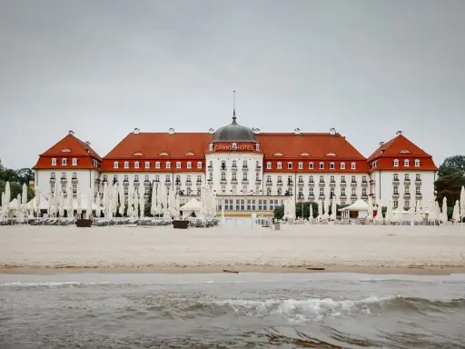 Majestatyczny Grand Hotel Sopot, z czerwoną dachem i białymi fasadami, stoi nad morzem. Jego historia jest równie imponująca jak widok.