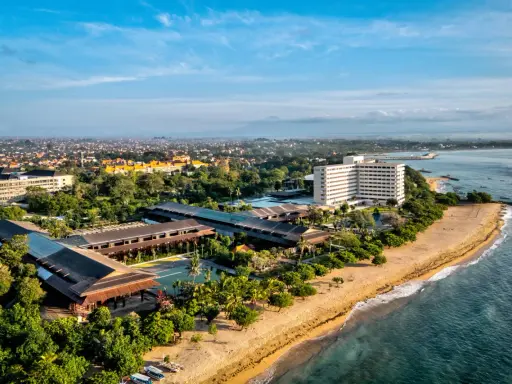Widok z lotu ptaka na wybrzeże Sanur z hotelami, basenami i plażą.