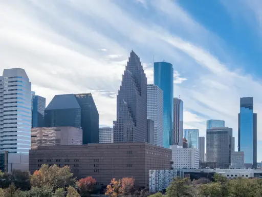 Widok na centrum Houston, największe miasto Teksasu, z drapaczami chmur i drzewami w jesiennych barwach.