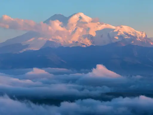 Elbrus, najwyższy szczyt Kaukazu, lśni w blasku wschodzącego słońca, otoczony morzem chmur.