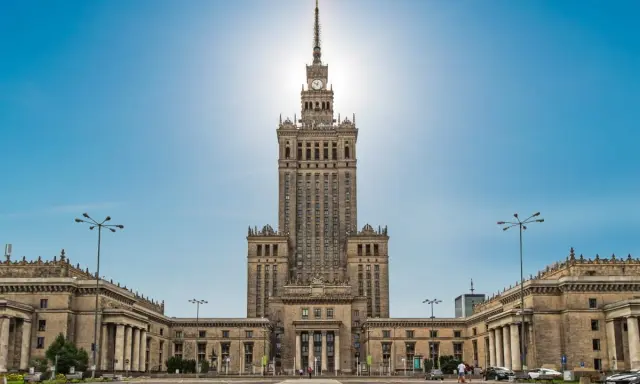 Imponujący Pałac Kultury i Nauki w Warszawie, jego monumentalna wysokość dominuje nad placem.