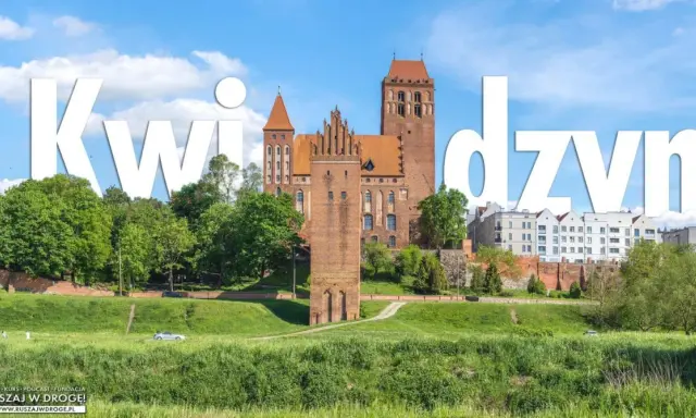 Zamek w Kwidzynie, imponująca budowla z cegły, góruje nad zielonym krajobrazem.
