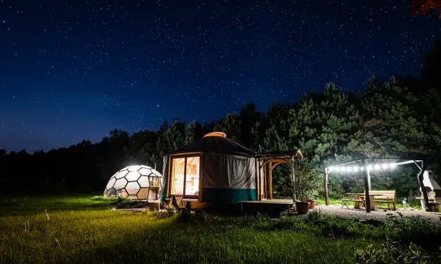 Nocne niebo nad jurta i kopułą. Idealne romantyczne miejsca w Polsce na wspólne chwile pod gwiazdami.