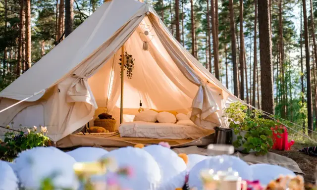 Glamping co to? Luksusowy namiot w lesie, z wygodnym łóżkiem i dekoracjami, zaprasza do odpoczynku na łonie natury.