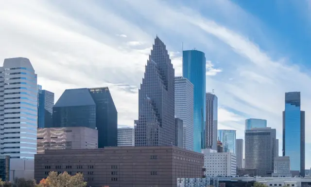 Widok na centrum Houston, największe miasto Teksasu, z drapaczami chmur i drzewami w jesiennych barwach.
