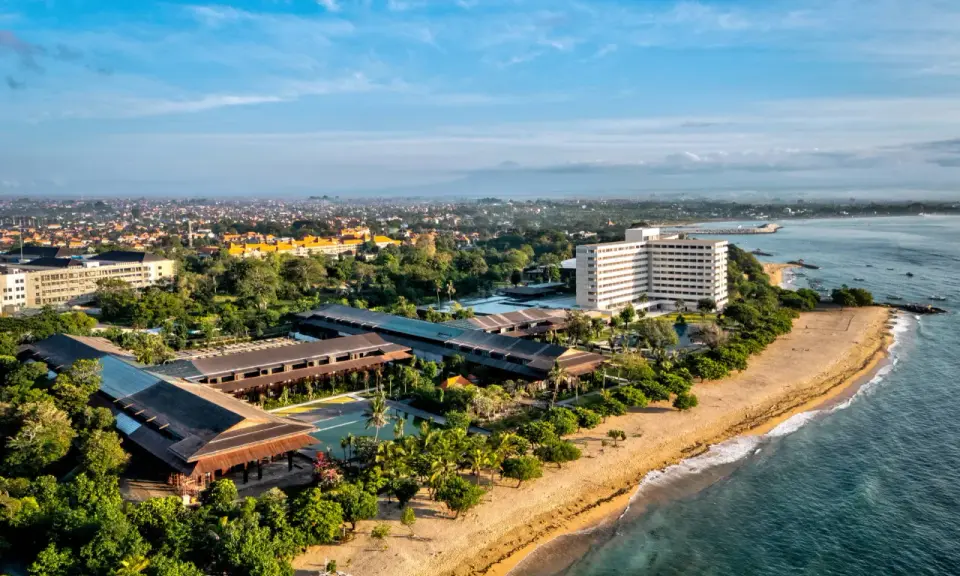 Widok z lotu ptaka na wybrzeże Sanur z hotelami, basenami i plażą.