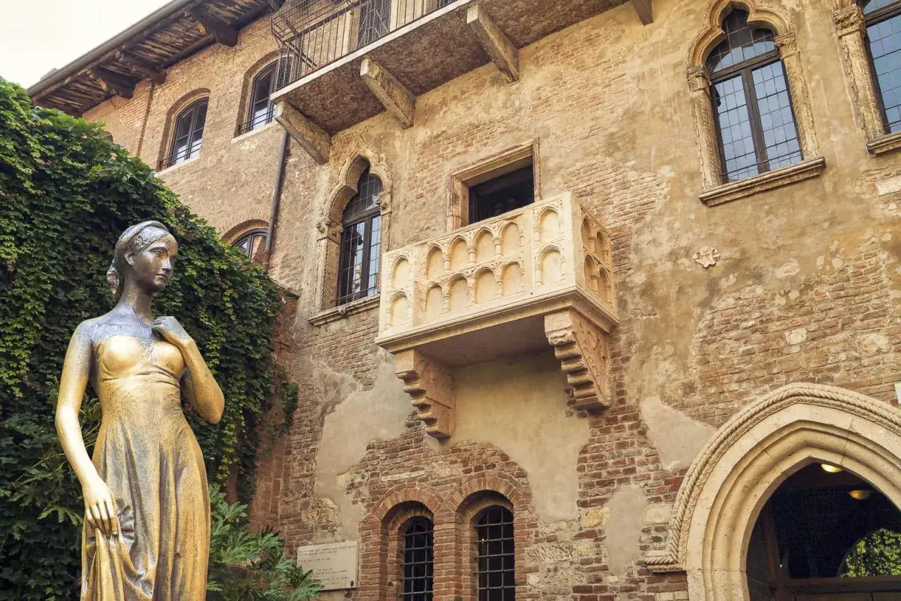 Posąg Julii stoi przed domem, który jest symbolem miasta Romea i Julii. Balkon i kamienne mury przywołują atmosferę tej słynnej historii miłosnej.