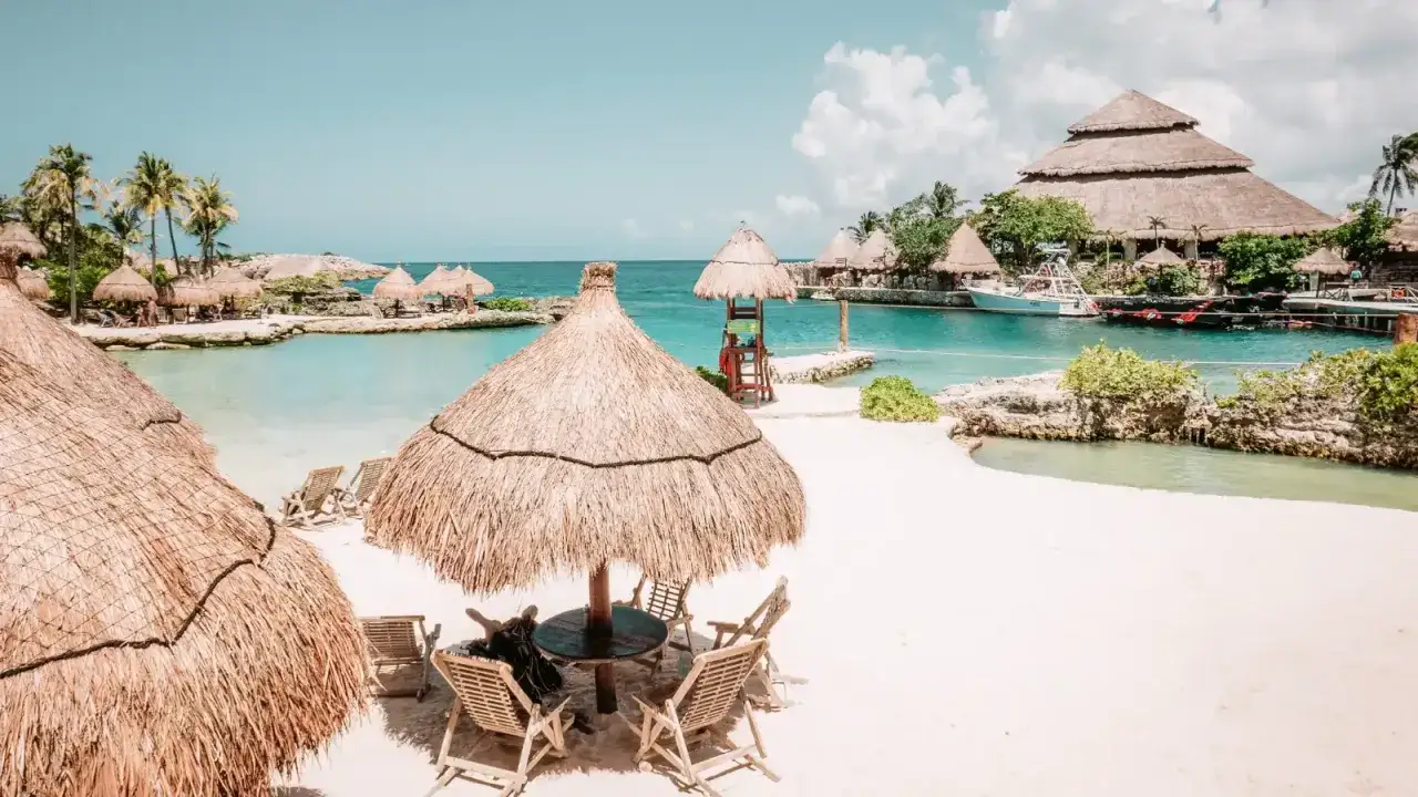 Rajska plaża z białym piaskiem, turkusową wodą i strzechami. Idealne miejsce, by zapytać, gdzie lecieć w październiku.