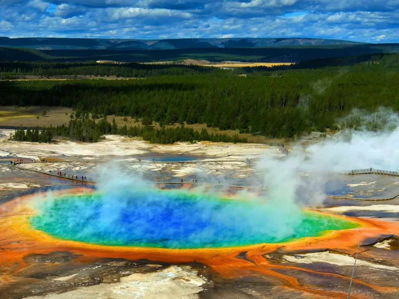 Wielobarwny gorący źródło w najstarszym parku narodowym na świecie, Yellowstone. Wokół turkusowej wody widoczne pomarańczowe i żółte osady.